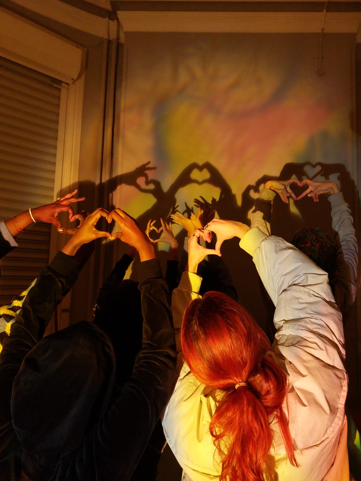 Hearts making hands, casting a shadow on the wall